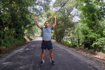 Normal weight man cross jumping to Warm Up for a Workout