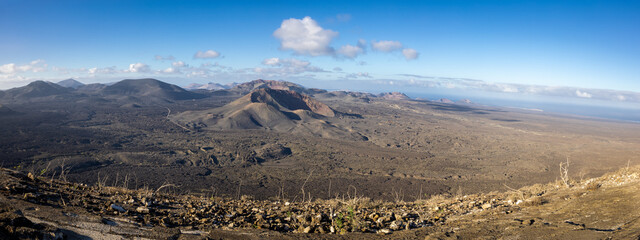 Panoramic image of the Timanfaya National Park shot from the highest point of crater Caldera Blanca on early morning. Lanzarote island, Spain. - obrazy, fototapety, plakaty