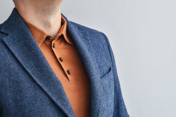 Fragment of blue tweed or woolen blazer combined with beige polo. Selective focus. - obrazy, fototapety, plakaty