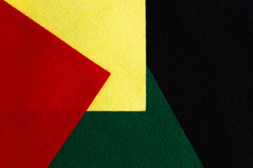 Geometric felt fabric textile background in black, red, yellow, green colors. Black History Month color background with copy space for text.