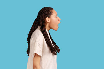Side view portrait of happy surprised beautiful woman with black dreadlocks notices something...