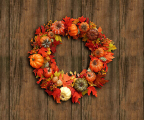 Symbolic autumn wreath on the background of wooden planks