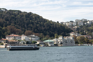 Naklejka premium View of a cruise tour yacht on Bosphorus and Bebek neighborhood on European side of Istanbul. It is a sunny summer day. Beautiful travel scene.