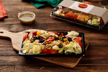 Greek Salad with tomato, cucumber and olice served in a dish isolated on wooden table background side view of fastfood