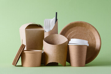 A set of paper packaging and utensils for fast food on a green background. The concept of rejection of plastic and zero waste.