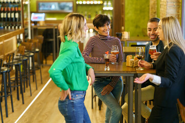 Blond woman speaking with friends in pub