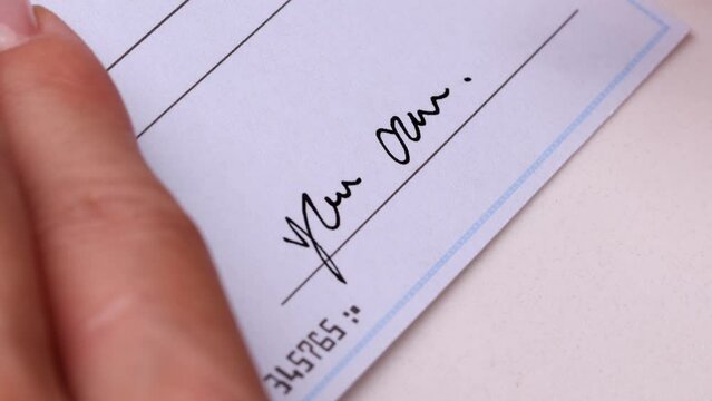 Close-up shot of a check being writen.