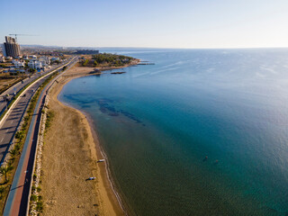 Beautiful beach in the background of the city. Cyprus, Long Beach. Blue lagoon of the Mediterranean Sea, highway.