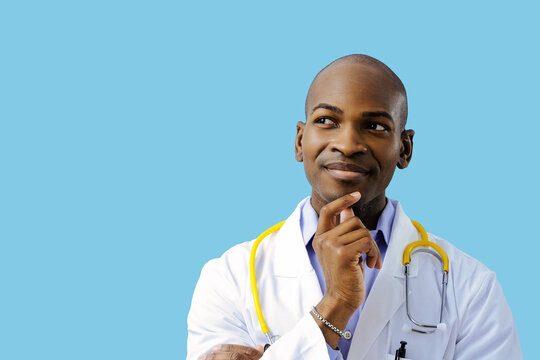 close up doctor smiling hand on chin looking at copy space wearing lab coat and stethoscope indoors studio