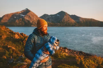 Foto op Plexiglas Father carrying baby outdoor family travel in Norway active vacations hiking healthy lifestyle man parent walking with infant child autumn season © EVERST
