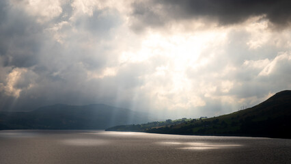 Photograph showing dramatic light rays through the clouds over Loch Tay in Scotland