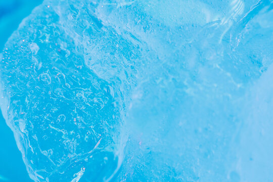 Global warming. Melting blue ice macro shot. Natural crystal clear flowing water. Creative background