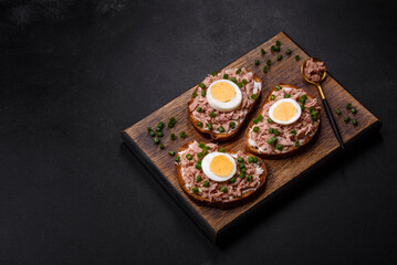 Delicious healthy sandwich with tuna, croutons, boiled egg, herbs and butter