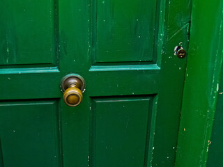 Closeup of closed green door with round brass knob - Powered by Adobe