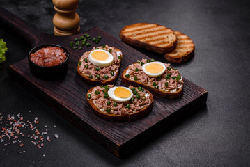 Delicious healthy sandwich with tuna, croutons, boiled egg, herbs and butter