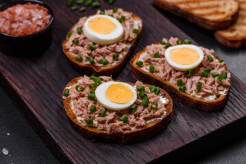 Delicious healthy sandwich with tuna, croutons, boiled egg, herbs and butter