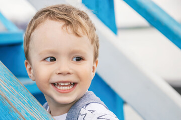 portrait of blonde cheerful kid outdoor, happy baby, real children's emotions