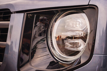 close-up of modern LED headlight lenses on car, concept of safety of drivers and passengers in cars, modern automotive technologies, toned