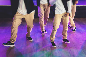 Group of hip-hop dancers performance on a stage, modern contemporary street dance with break dancing in studio, hip hop dance training  in a ballroom, legs in sneakers close up