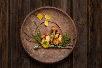Fresh beautiful forest suede bolete mushrooms on vintage wooden dish