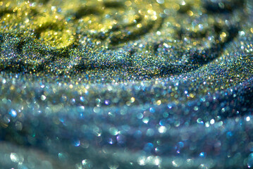 Shiny yellow green blue turquoise glitter textured blurred background