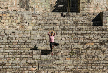Yoga pose on the Ball Court at the Copan Mayan Ruins, Copan Ruinas, Honduras