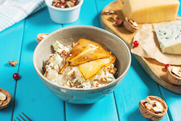 Pear and gorgonzola oatmeal with walnuts on blue wooden table