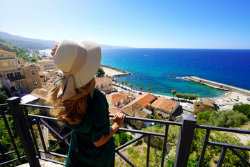 Tourist woman with hat enjoying view in Pizzo Calabro, Italy