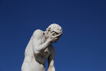 Caïn by Henri Vidal, Tuileries Garden, Paris, 1896. Funny face palming statue background with copy space. Concept for frustration, failure, annoyance. Statue Cain coming from killing his brother Abel - obrazy, fototapety, plakaty