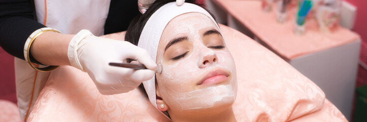 Girl with facial mask lying in beauty health spa center	