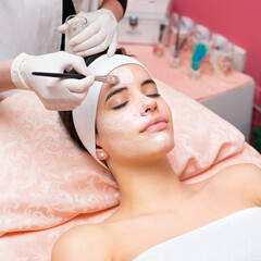Obraz na płótnie Canvas Girl with facial mask lying in beauty health spa center 