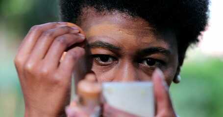 African woman applying mascara foundation make-up