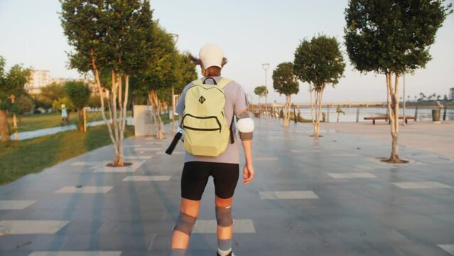 Woman rollerblade on. Young athletic girl rollerblading quickly rides through the park.