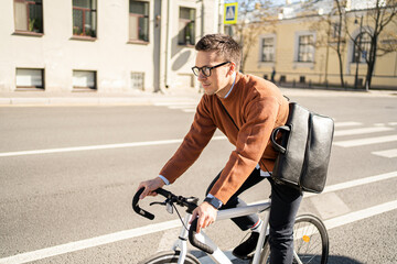 A male cyclist rides a bicycle to work in the city, eco transport.