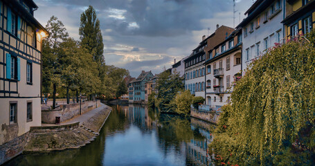 Fototapeta na wymiar View of the old buildings on the riverbanks reflecting on water of river Ill, Strasbourg