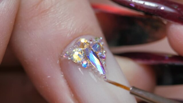 Applying a three-dimensional pattern with rhinestones and broths on the nail.