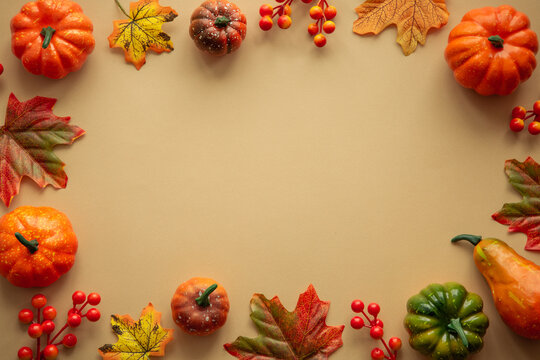 Autumn flat lay background with copy space at color paper. Pumpkins, leaves and decorations.