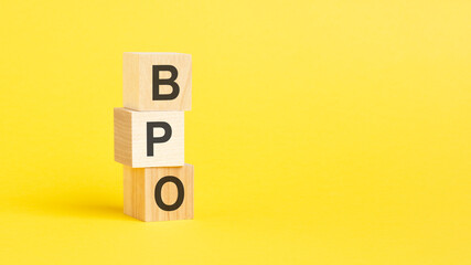 BPO - text on wooden cubes, on yellow background