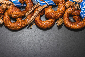 Oktoberfest concept - pretzels with traditional pattern ribbon and ears of wheat