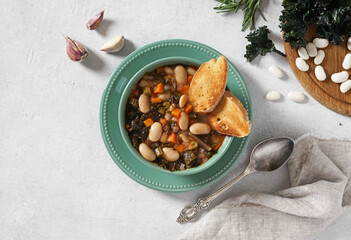 Homemade Ribollita, tuscan bean soup with light rye ciabatta, top view