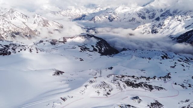 flying above the clouds in the snowy mountains over the houses for climbers in the form of barrels. beautiful sunny view of the camp on the slope of Elbrus - the highest mountain in Europe.