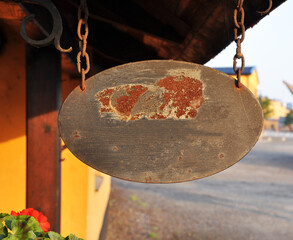 Old, rusty sign with a chain