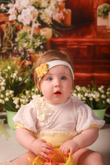 portrait girl one year old shooting in the studio in the background flowers wooden background dekor 