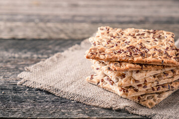 Crackers with sunflower seeds and sesame on rustic background. Copy space