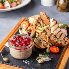 Duck pate in a glass served with crispy bread.