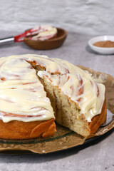 giant cinnamon roll with buttercream frosting,, grey marble table