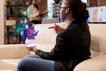Businesswoman using augmented reality hologram in company office, working with artificial intelligence holographic concept to talk to manager. Planning startup presentation with online data report.