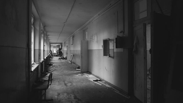 Interior on ukrainian school after shelling. Black and white 4k video panorama of broken torn corridor of school in Chernihiv city, Ukraine. Causes of war of Russia against Ukraine in 2022 concept