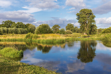 Trave mit Spiegelung des Himmels und der Vegetation im Wasser bei Bad Oldesloe in...