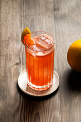 Picture of grapefruit garibaldi cocktail in a highball glass with a grapefruit